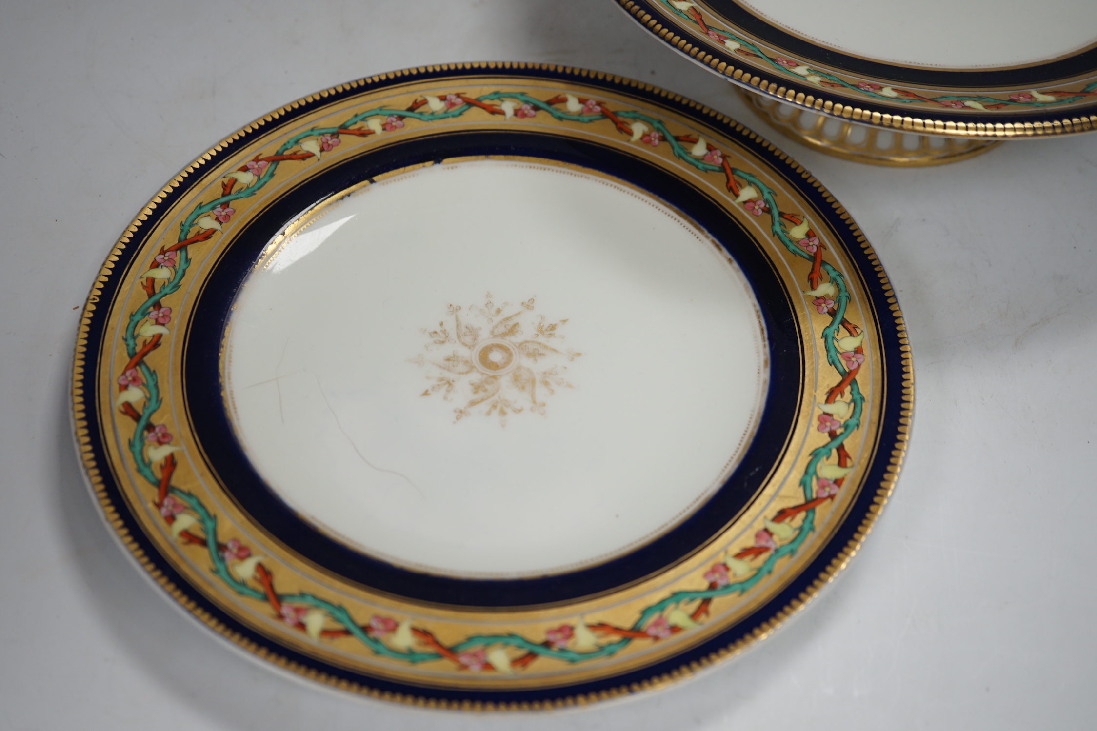 A Victorian bone china dessert service comprising eleven plates and four pedestal dishes, 23cm in diameter